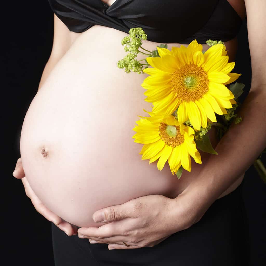 妊婦のお腹とひまわりの花を組み合わせたマタニティフォト撮影
